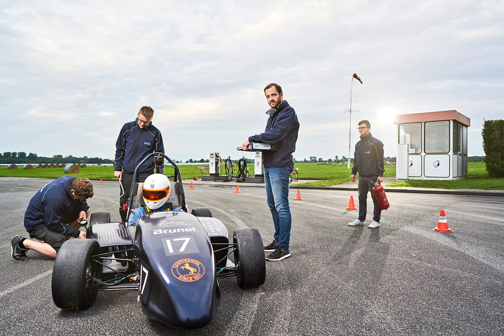Mitglieder des Baltic Racing Teams mit Rennwagen auf Rennstrecke beim Boxenstopp