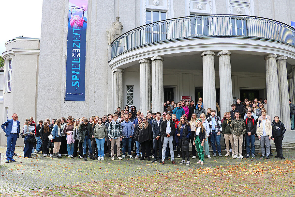 Alle neuen Studierenden stehen mit de Rektor vor dem Theater in Stralsund