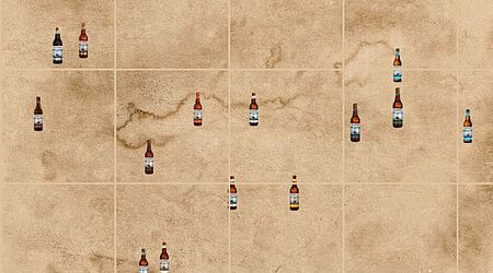 Mehrere Bierflaschen sind über eine vermeintliche Karte (eigentlich nur altes Papier mit Wasserflecken) in einem Raster verteilt.