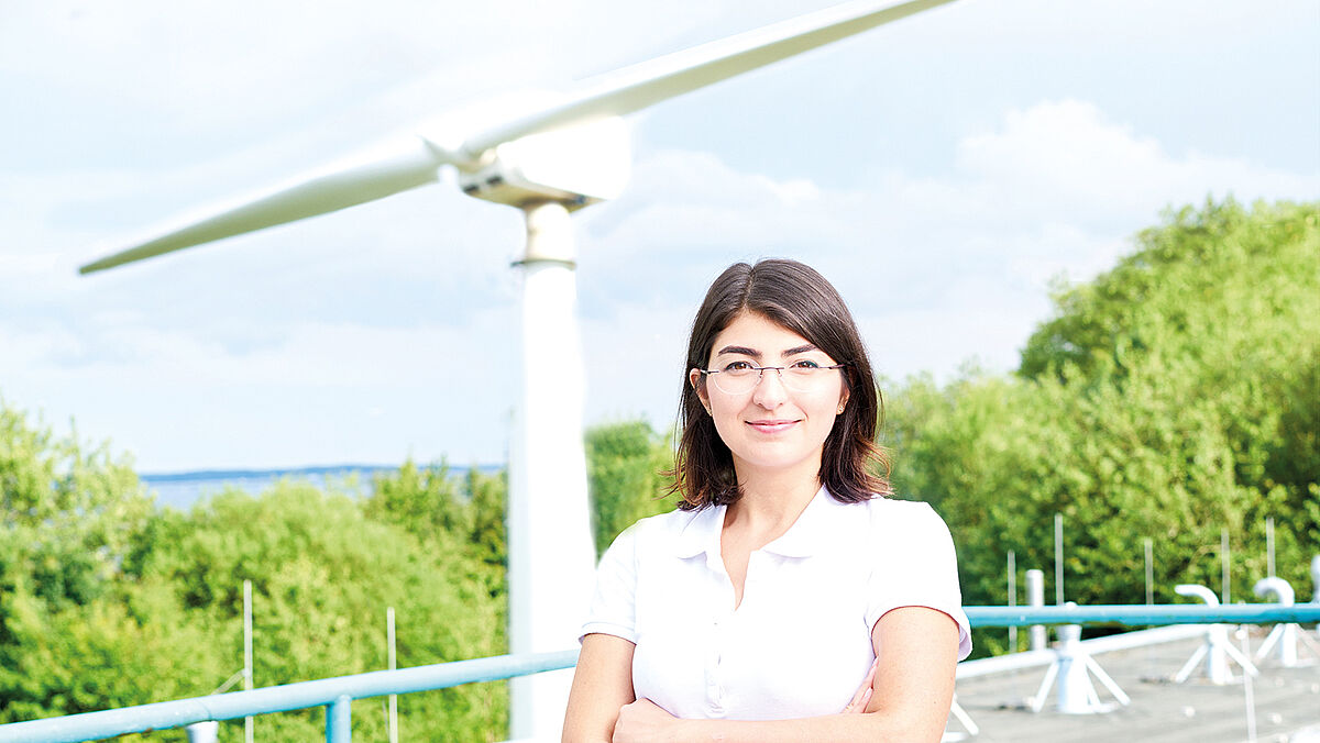 Student in front of a wind turbine