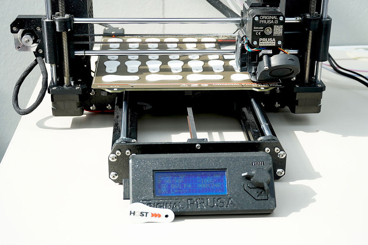 Ein Gerät zum Drucken von Schlüsselanhängern mit dem HOST Logo.