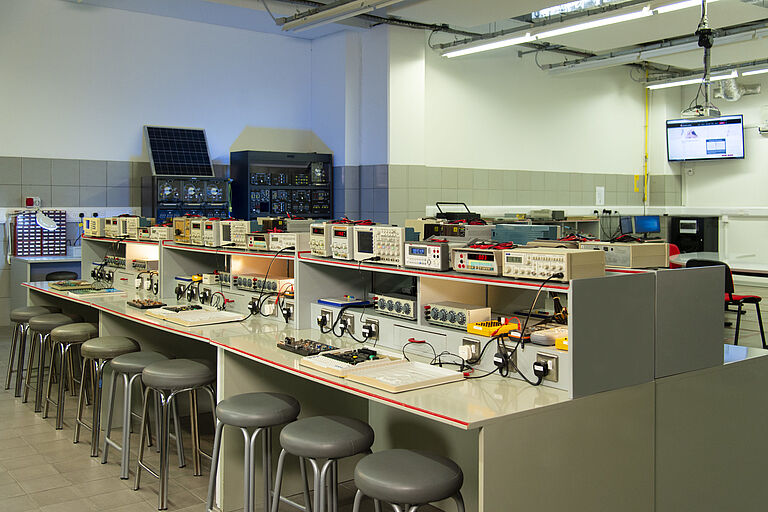 Blick in ein Labor mit vielen Stromzählern an mehreren Arbeitsplätzen