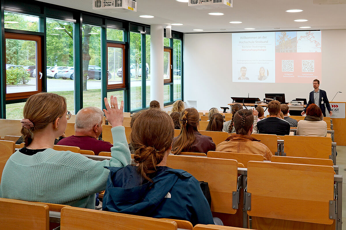 Besucher bei der Studiengangs Vorstellung in einem Hörsaal und Professor steht vorn und erzählt
