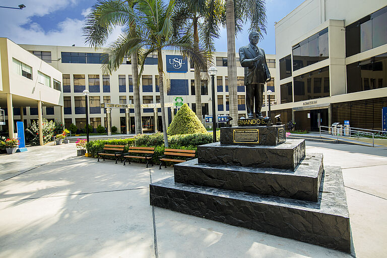 Die Statue eines Mannes vor einem Universitätsgebäude.