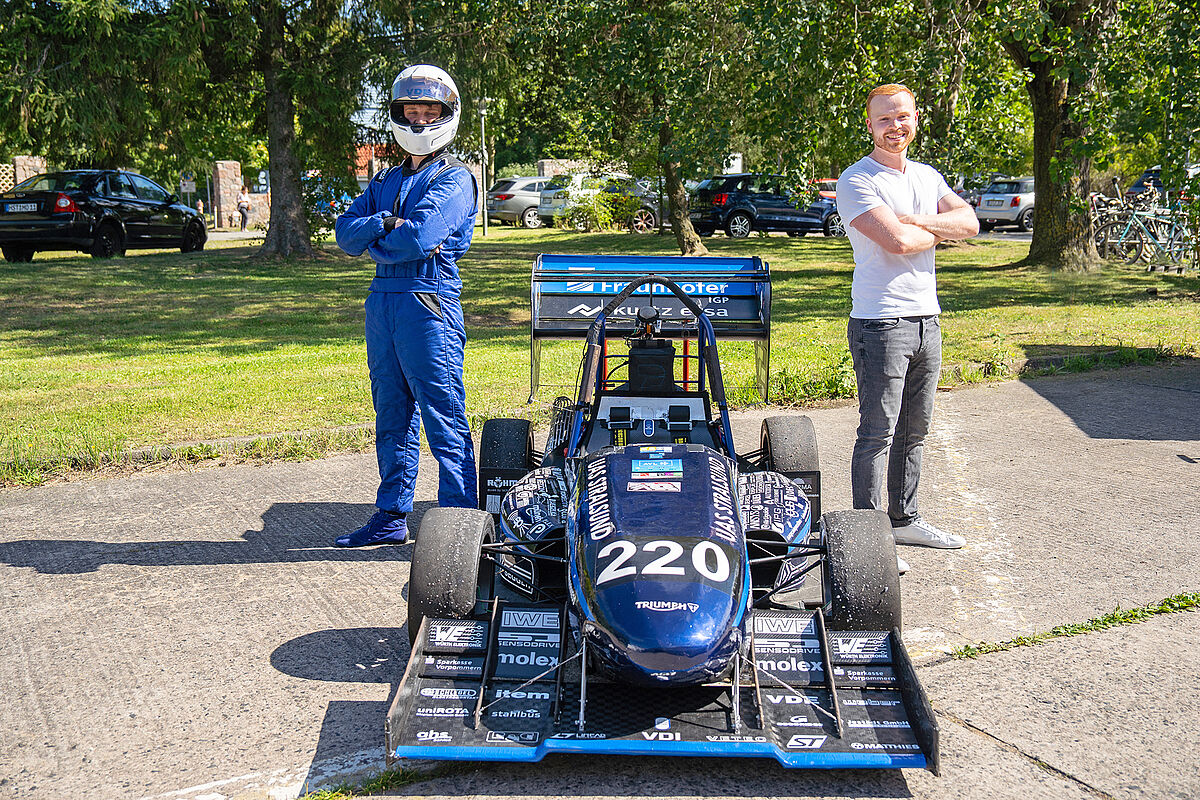 zwei Jungs stehen neben dem selbstgebauten Rennwagen - Baltic Racing