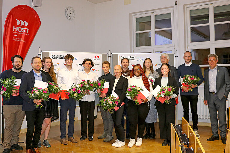 Ein Gruppenfoto von Stipendiat*innen und Fördermittelgeber*innen mit Blumen