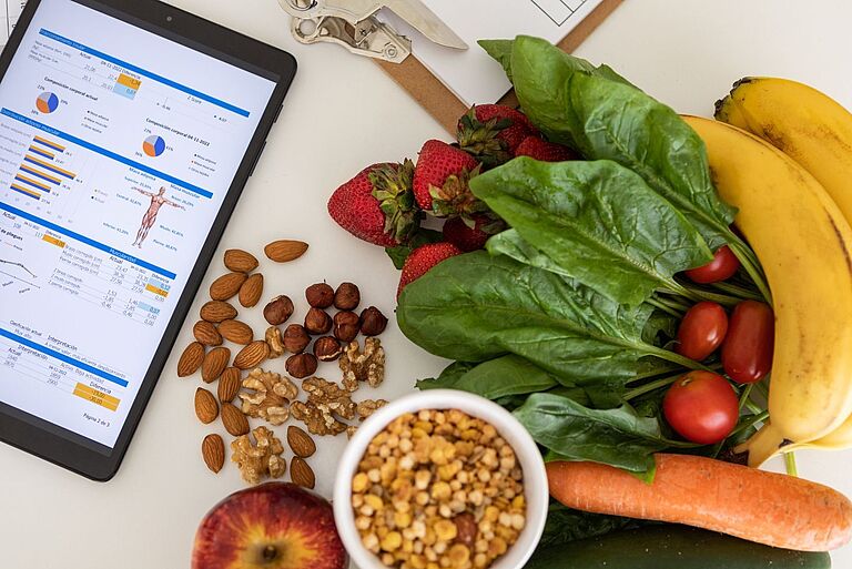 Ein Tablet-Bildschirm liegt neben dem Obst und Gemüse