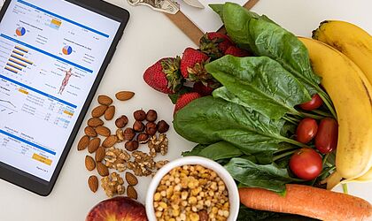 Ein Tablet-Bildschirm liegt neben dem Obst und Gemüse