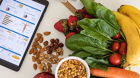 Ein Tablet-Bildschirm liegt neben dem Obst und Gemüse