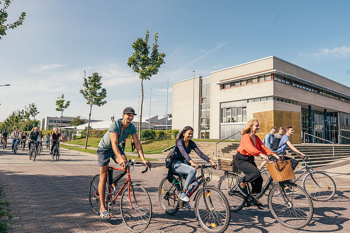 Students ride bicycles on the campus of Stralsund University of Applied Sciences