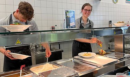 2 Studierende stehen hinter dem Mensa-Tresen