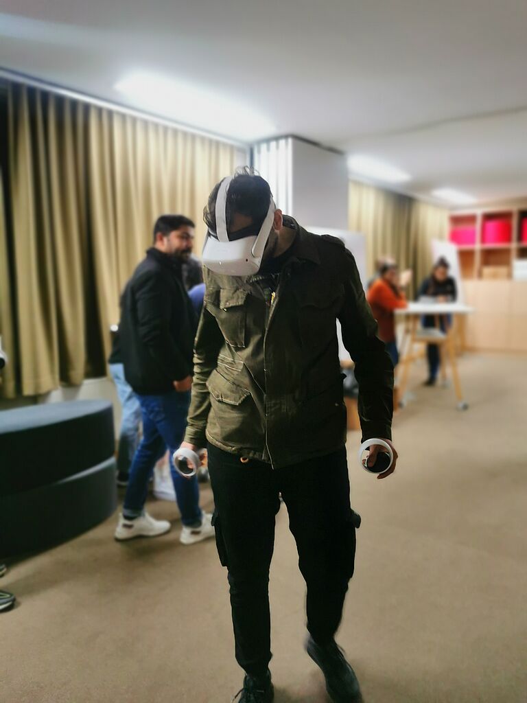 Ein junger Mann geht mit einer VR-Brille einen Flur entlang.