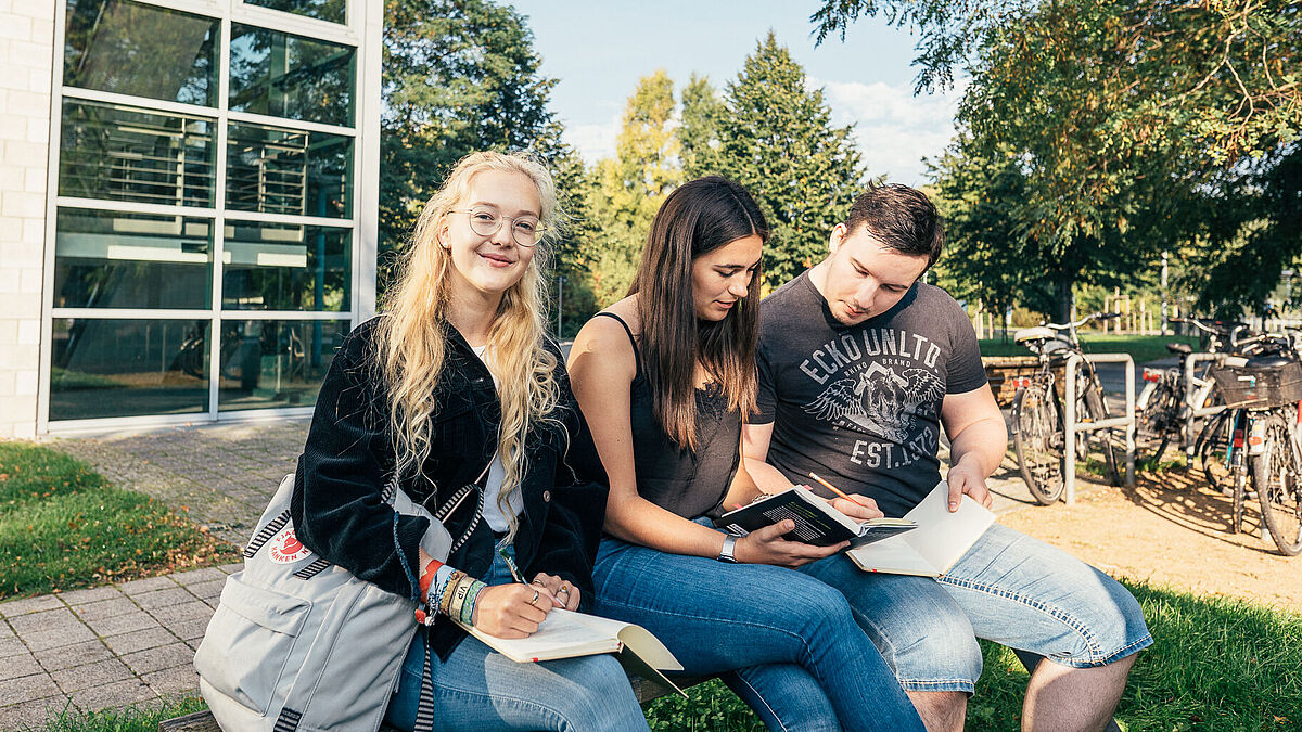 Studierende lernen vor der Fakultät für Wirtschaft.