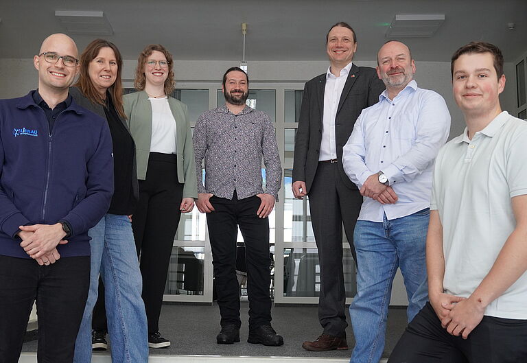 Christian Eschenburg, Liane Kantz, Marie Schlosser, Sven Klimaschewski, Prof. Dr.-Ing. Mark Vehse, Dr. Kai Masur und Torben Haupt  posieren für ein Gruppenfoto auf einer Treppe
