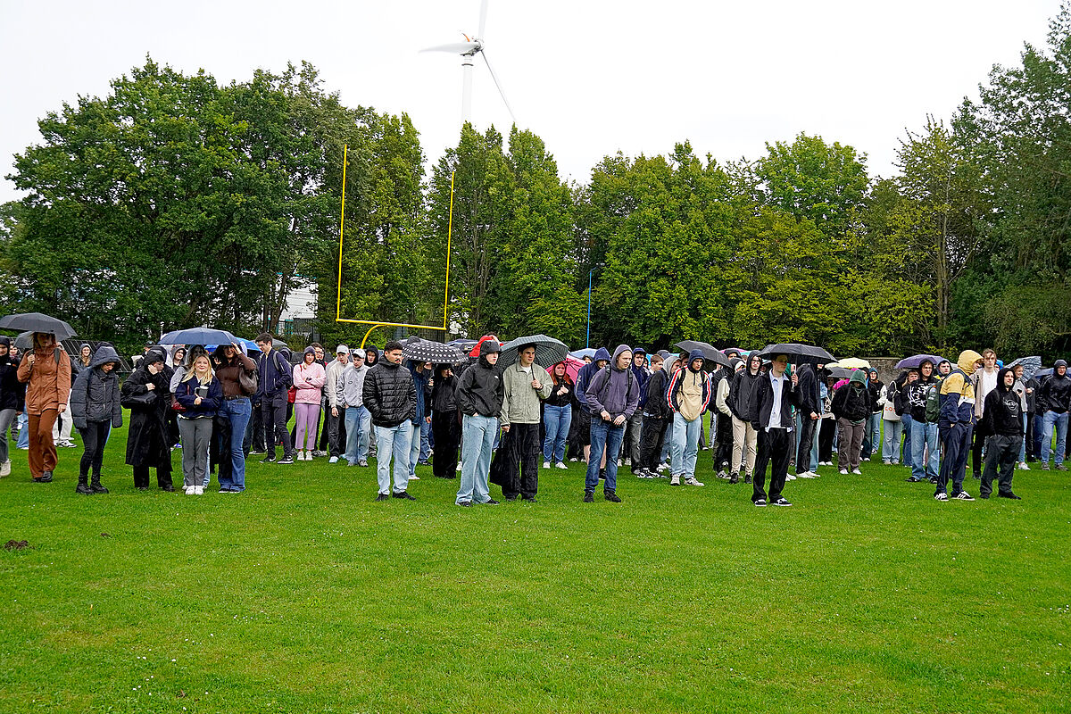 Die Erstsemester zur Begrüßung im Regen auf dem Sportplatz