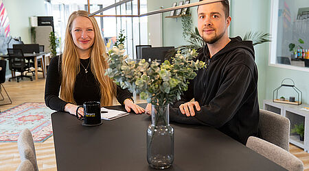 Doreen Mlodzik mit Lennart Deorocki sitzen während eines Gesprächs an einem Tresentisch in der Orangery Stralsund