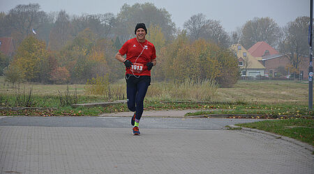 Prof. Ralph Sonntag mit Mütze, Handschuhen und rotem T-Shirt beim joggen.