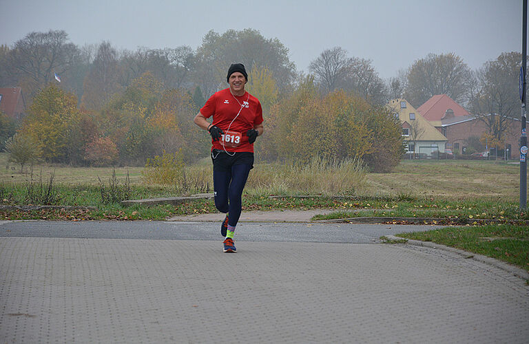 Prof. Ralph Sonntag mit Mütze, Handschuhen und rotem T-Shirt beim joggen.