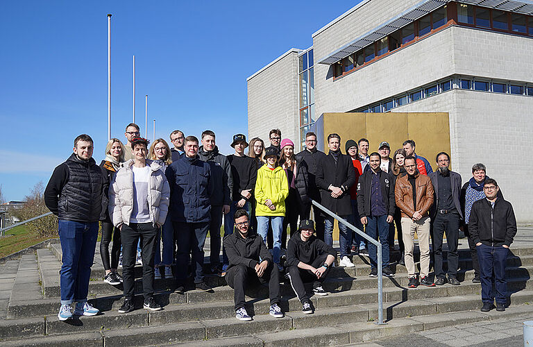 Gruppenfoto der 22 Teilnehmer der 30. Spring School mit Mitarbeitern der HOST auf einer Treppe vor der Fakultät für Maschienenbau