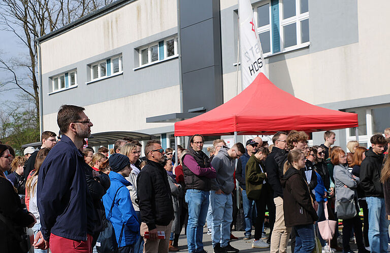 eine große Menschengruppe auf dem Mensavorplatz, die einer Rede zum Campus-Tag lauscht