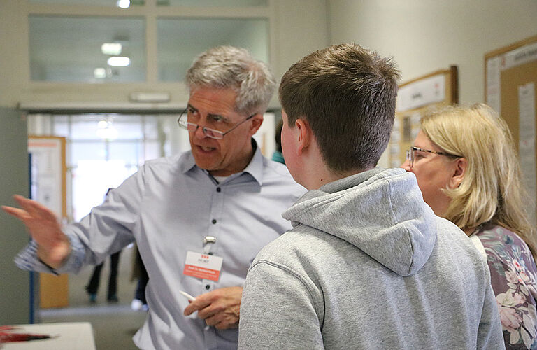 Prof. Michael Koch im Gespräch mit einer Familie beim Campus-Tag der HOST