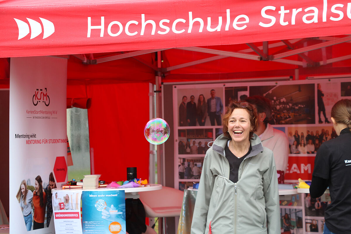 Eine Frau am Stand und davor eine Seifenblase